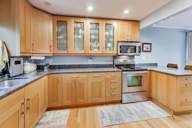 2609 Eisenhower Dr, Des Plaines, IL 60018 - kitchen featuring appliances with stainless steel finishes, a peninsula, dark stone counters, light wood finished floors, and recessed lighting