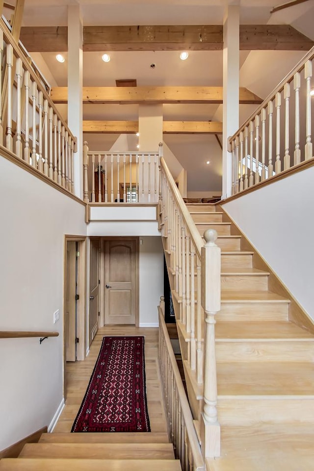2609 Eisenhower Dr, Des Plaines, IL 60018 - stairway featuring beam ceiling, a high ceiling, wood finished floors, and recessed lighting