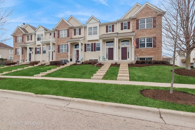 multi unit property featuring a front yard, brick siding, and a residential view