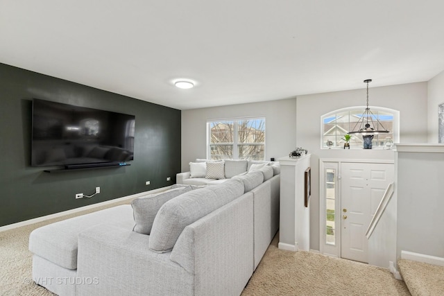 living room featuring a chandelier, carpet flooring, and baseboards