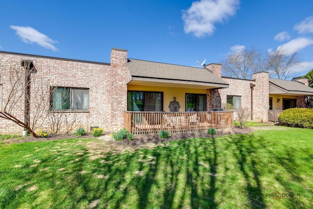 view of front of house with a front lawn, brick siding, and a chimney