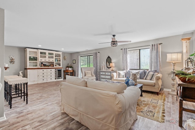 living area featuring wine cooler, light wood-type flooring, baseboards, recessed lighting, and ceiling fan