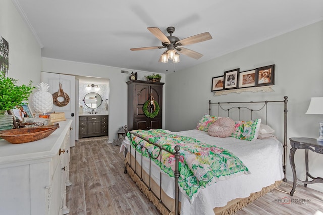 bedroom with a ceiling fan, crown molding, connected bathroom, light wood-type flooring, and visible vents