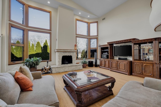 8209 N Oleander Ave, Niles, IL 60714 - living room with high vaulted ceiling, recessed lighting, a stone fireplace, and wood finished floors