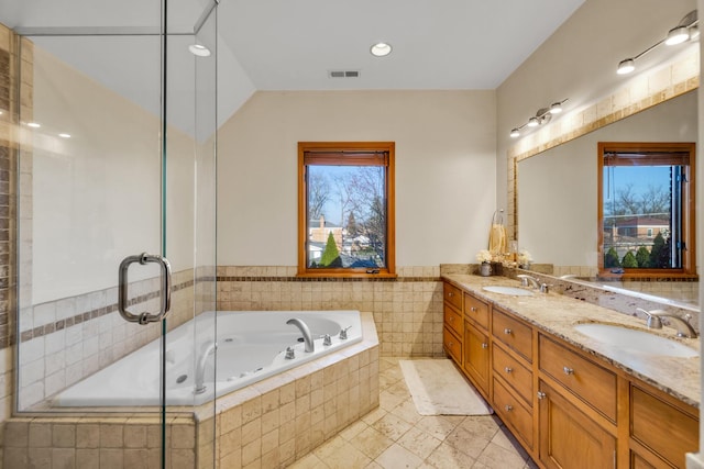 8209 N Oleander Ave, Niles, IL 60714 - bathroom featuring a garden tub, double vanity, tiled shower, a wainscoted wall, and tile walls