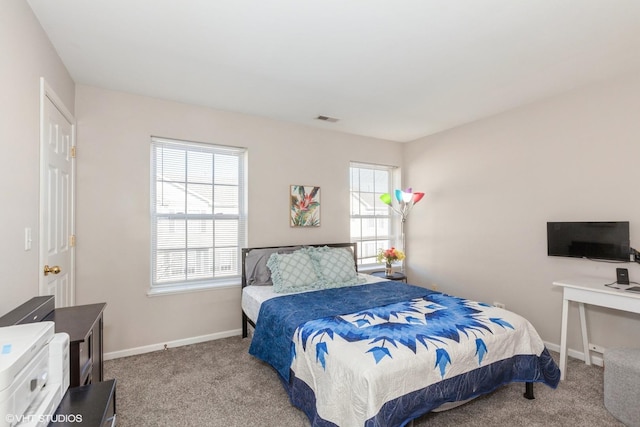 bedroom featuring carpet flooring, visible vents, multiple windows, and baseboards