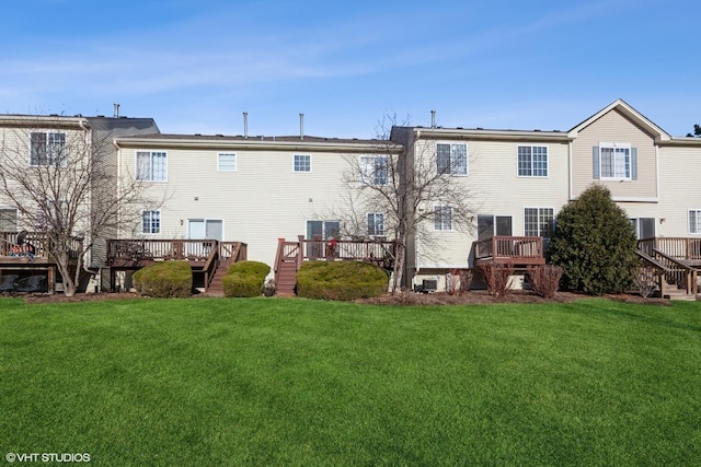 back of property with a wooden deck and a lawn