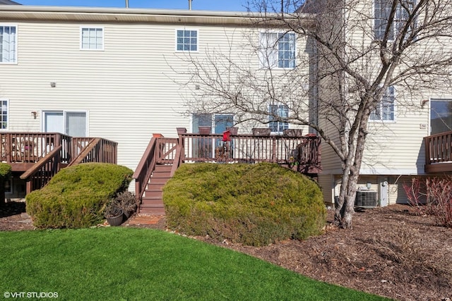back of property featuring cooling unit, a deck, a lawn, and stairs