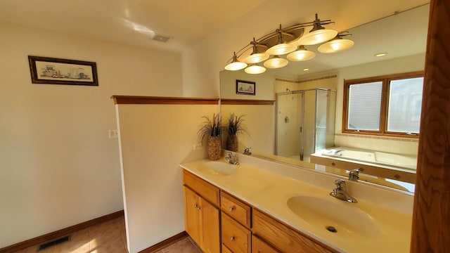 bathroom with a stall shower, a sink, and visible vents