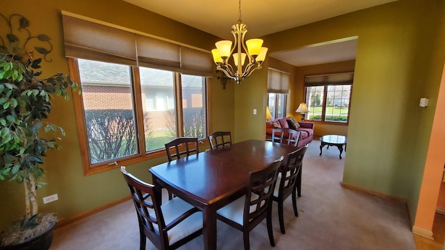 dining area with carpet flooring, a notable chandelier, and baseboards