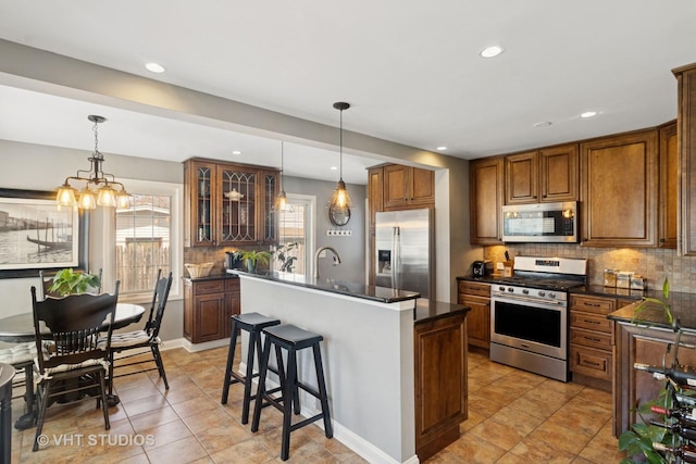 137 S Hickory St, Palatine, IL 60067 - kitchen with stainless steel appliances, decorative backsplash, brown cabinets, and dark countertops