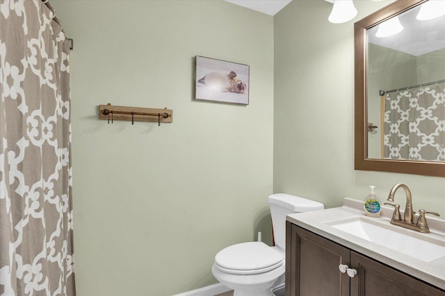 bathroom featuring toilet, curtained shower, and vanity