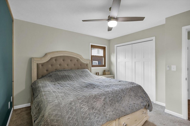 carpeted bedroom featuring a closet, baseboards, and a ceiling fan