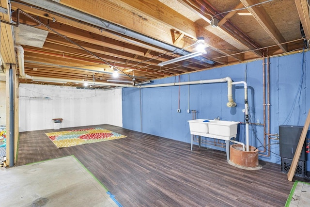 unfinished below grade area featuring wood finished floors and a sink