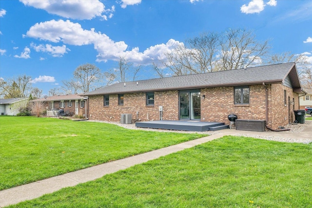 back of property with a patio area, brick siding, cooling unit, and a lawn