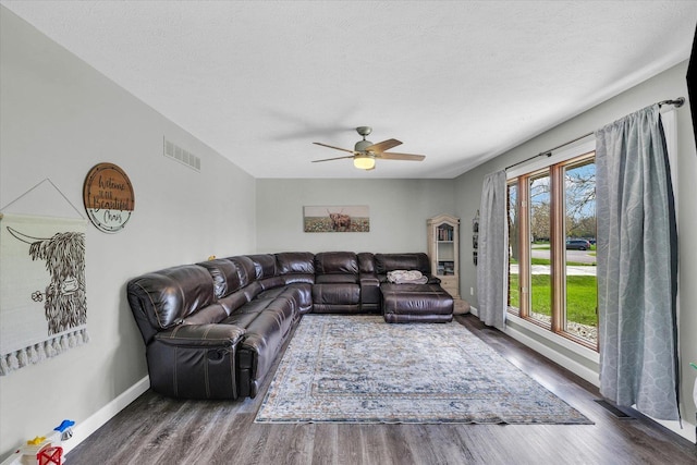 living area with wood finished floors, ceiling fan, baseboards, and visible vents