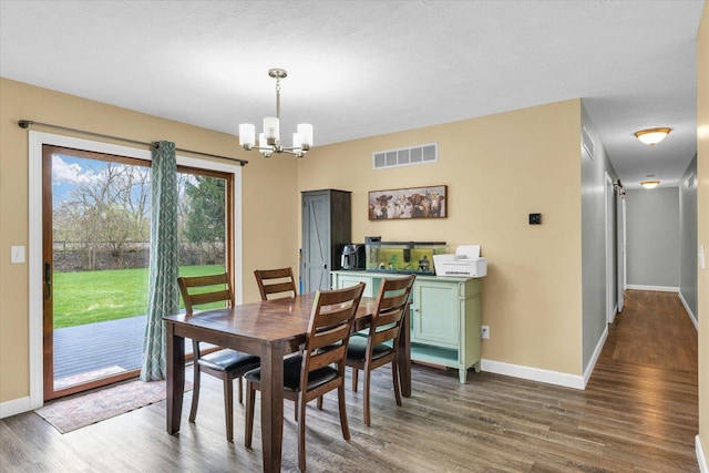 dining room with a chandelier, visible vents, dark wood-style flooring, and baseboards