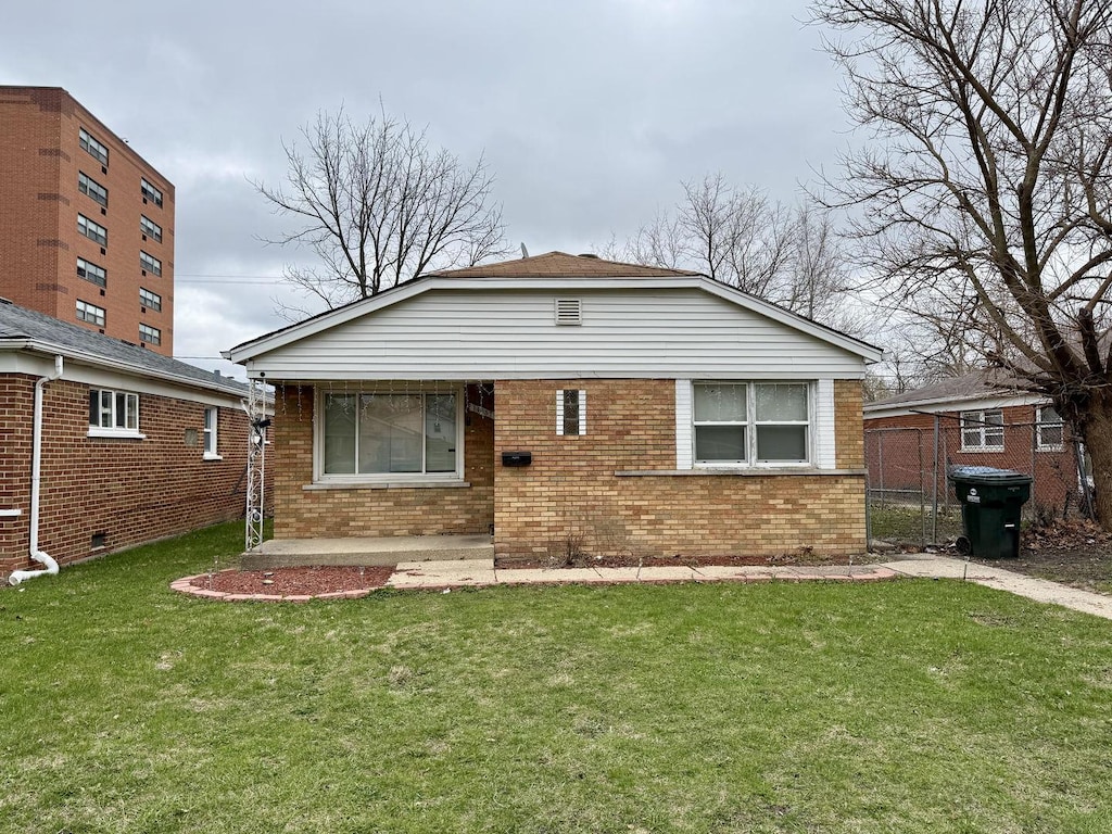 bungalow with a front yard and brick siding