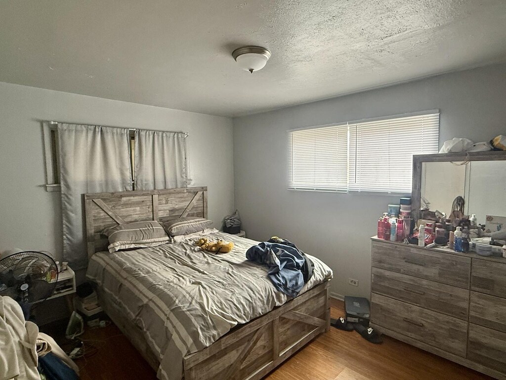 bedroom featuring wood finished floors and a textured ceiling