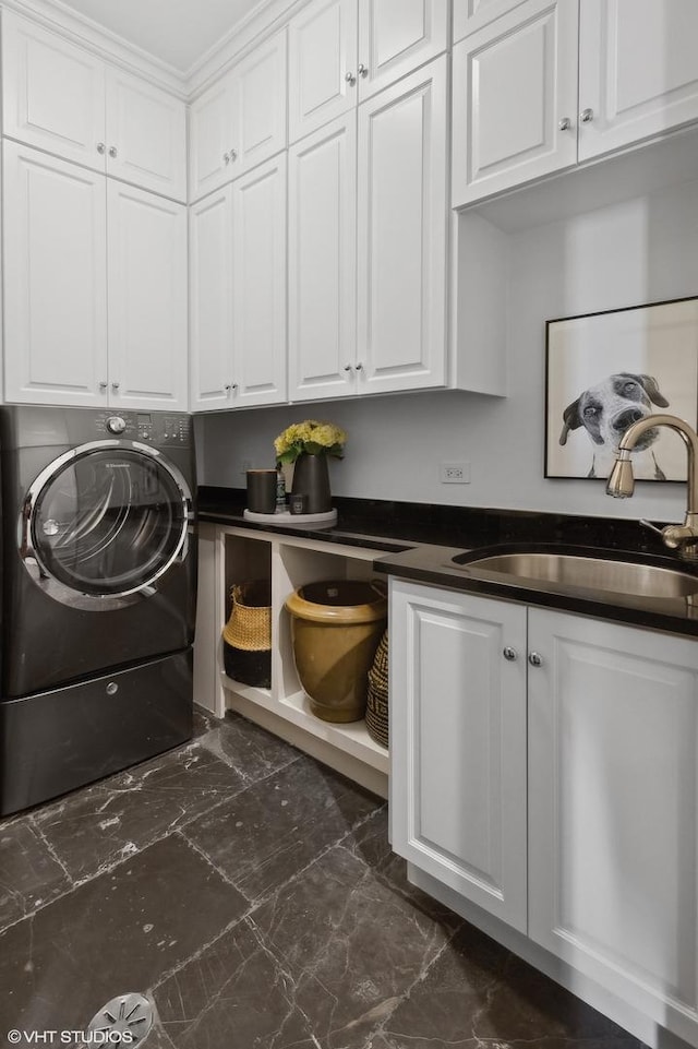 washroom with cabinet space, washer / dryer, and a sink