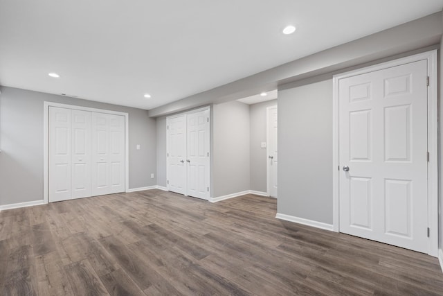 interior space with dark wood-type flooring, baseboards, multiple closets, and recessed lighting