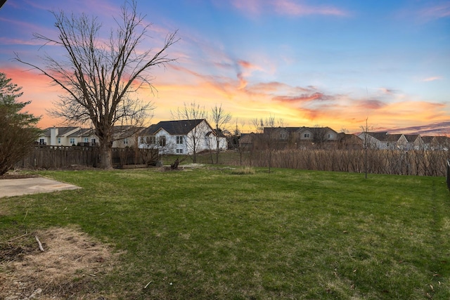 yard at dusk featuring fence
