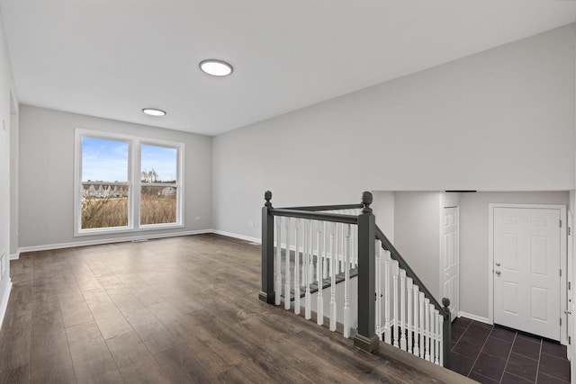 interior space featuring baseboards and dark wood-style floors