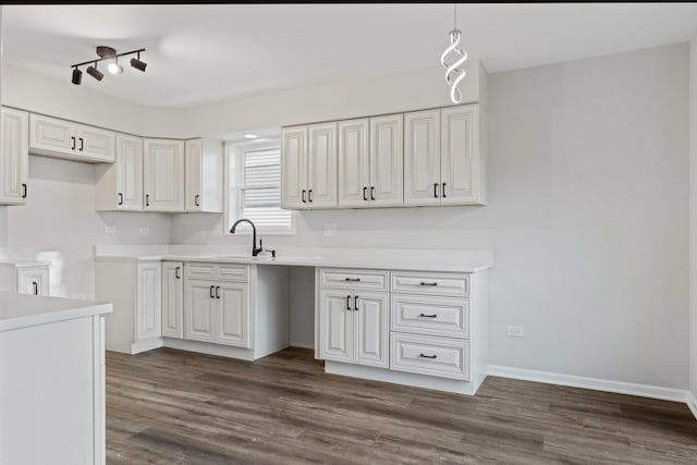 kitchen featuring a sink, light countertops, white cabinets, and dark wood-style flooring