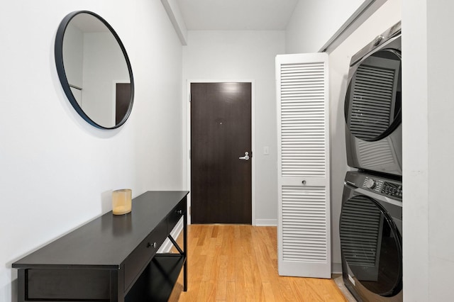 laundry room with light wood finished floors, laundry area, and stacked washer and clothes dryer