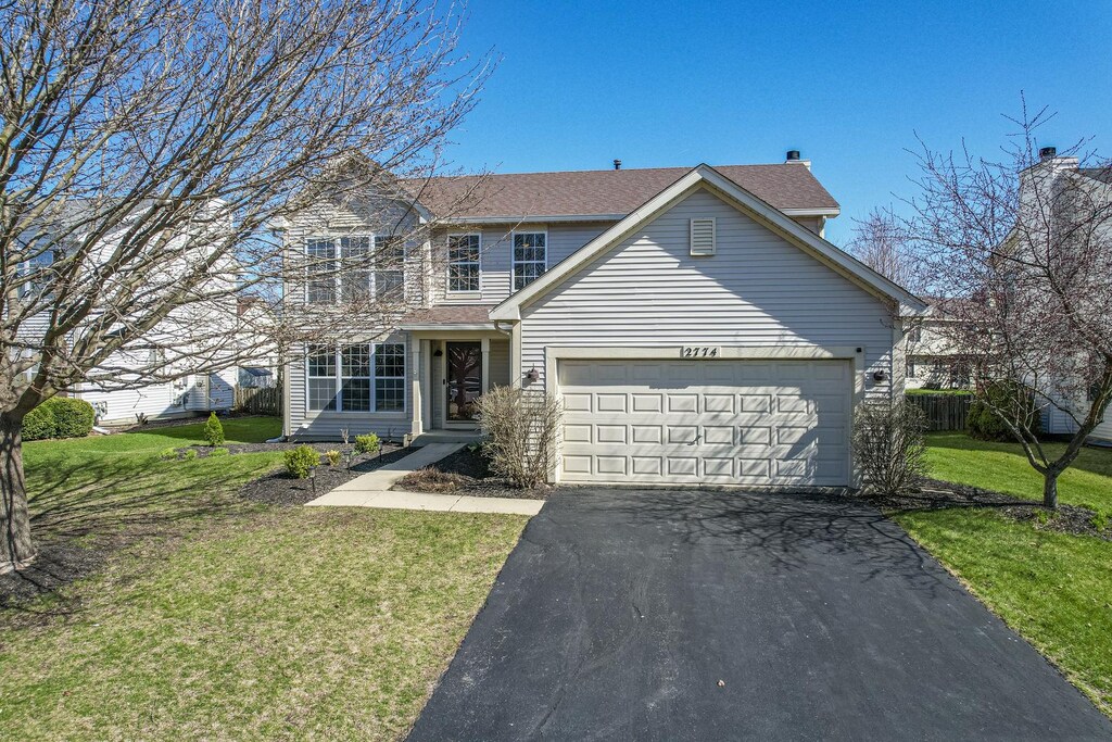 2774 Imperial Valley Trl, Aurora, IL 60503 - traditional-style home featuring aphalt driveway, roof with shingles, a front yard, a balcony, and an attached garage