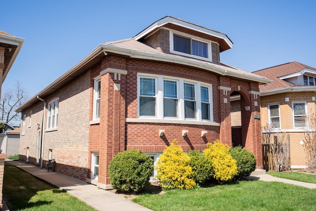 view of front of home featuring brick siding and a front lawn