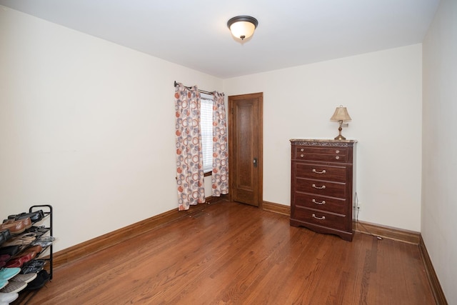 bedroom featuring baseboards and wood finished floors