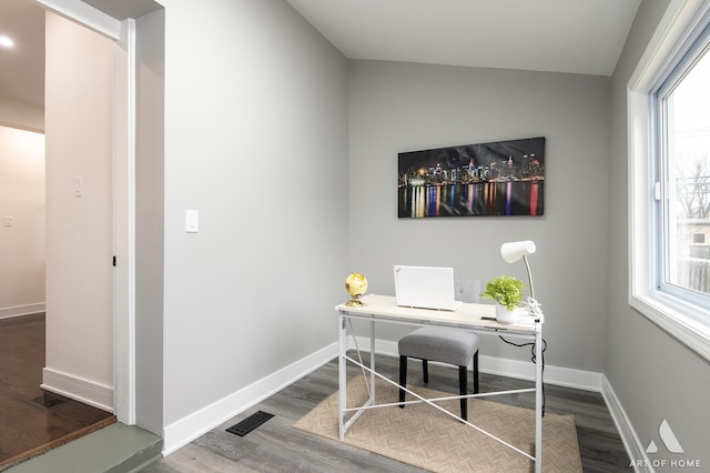 office area featuring visible vents, baseboards, plenty of natural light, and dark wood finished floors