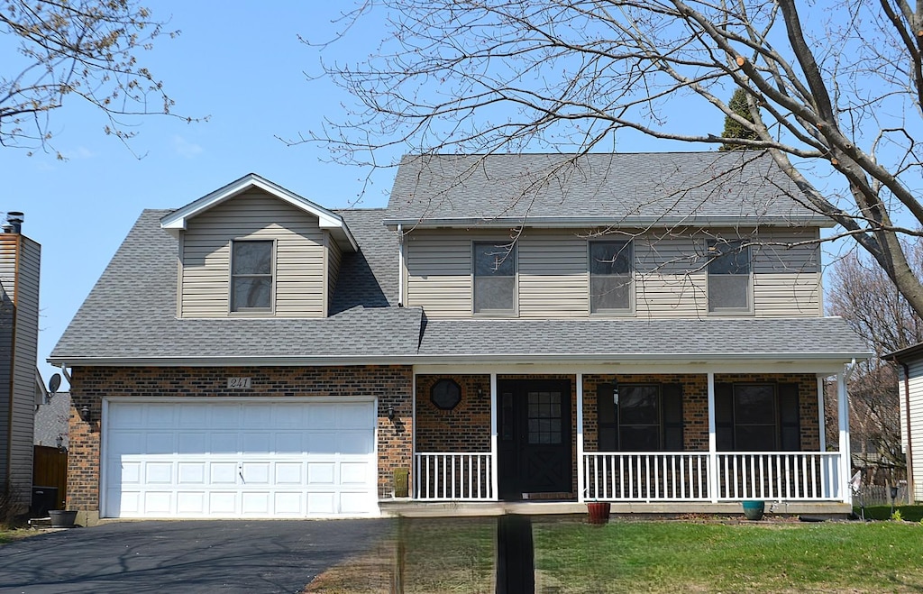 241 Butte View Dr N, Bolingbrook, IL 60490 - traditional home with roof with shingles, aphalt driveway, brick siding, and covered porch
