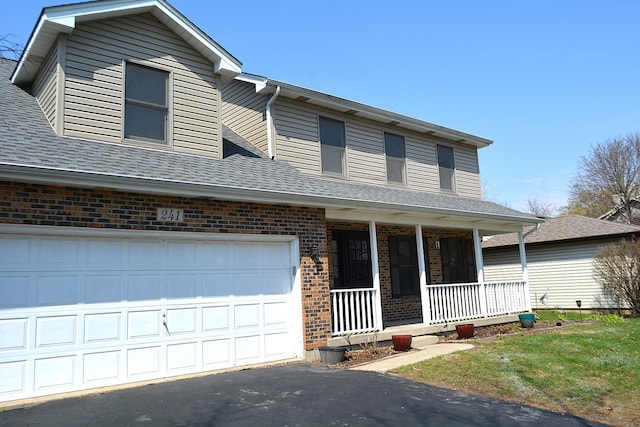 241 Butte View Dr N, Bolingbrook, IL 60490 - traditional-style home with roof with shingles, driveway, an attached garage, brick siding, and covered porch