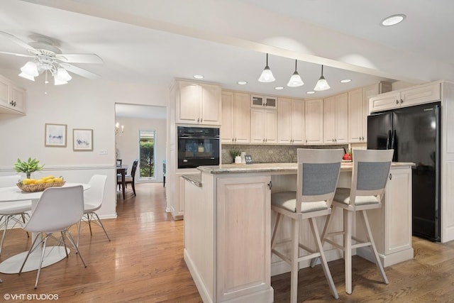 1115 S Vail Ave, Arlington Heights, IL 60005 - kitchen with black appliances, tasteful backsplash, light wood-type flooring, a kitchen bar, and a ceiling fan