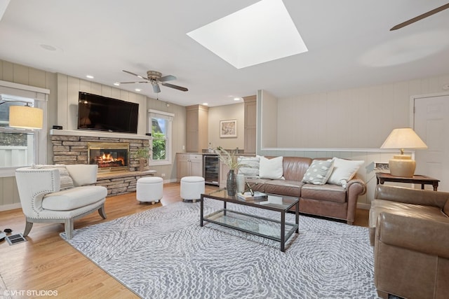 1115 S Vail Ave, Arlington Heights, IL 60005 - living room featuring ceiling fan, beverage cooler, light wood-style flooring, a fireplace, and a skylight