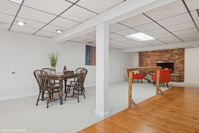 1115 S Vail Ave, Arlington Heights, IL 60005 - carpeted dining room featuring baseboards, a drop ceiling, a brick fireplace, and wood finished floors