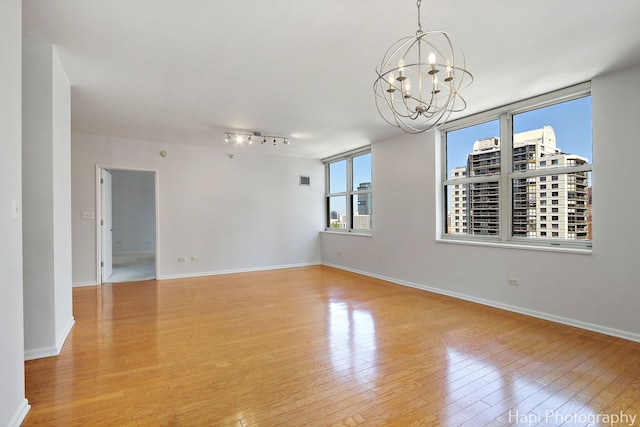 21 W Chestnut St Unit 1509, Chicago, IL 60610 - empty room featuring a chandelier, light wood-style floors, and rail lighting
