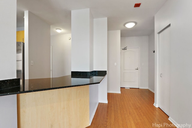 21 W Chestnut St Unit 1509, Chicago, IL 60610 - kitchen featuring hardwood / wood-style flooring, freestanding refrigerator, dark stone countertops, and a peninsula