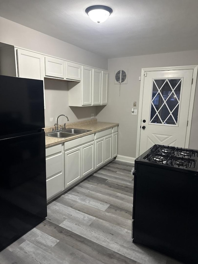 506 S Edison Ave, Elgin, IL 60123 - kitchen with black appliances, white cabinets, light countertops, and light wood-style floors
