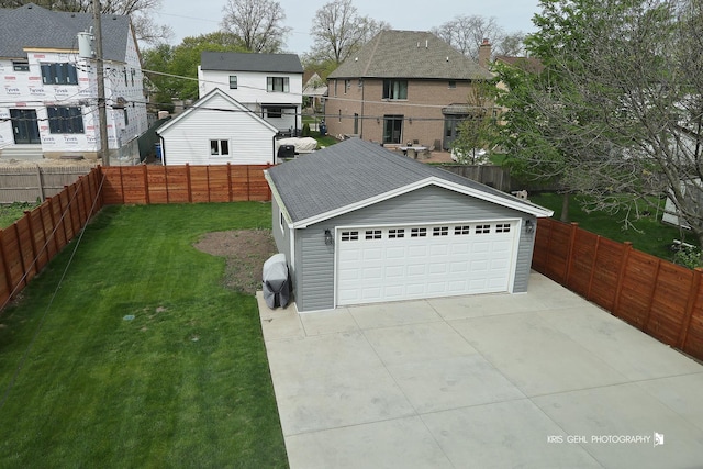 view of yard with a residential view, an outbuilding, a fenced backyard, and a garage