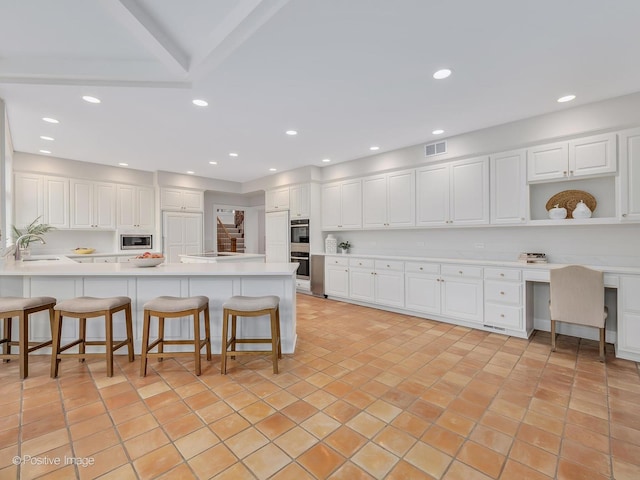 8 Longwood Dr, Burr Ridge, IL 60527 - kitchen featuring a kitchen breakfast bar, a peninsula, visible vents, appliances with stainless steel finishes, and a sink