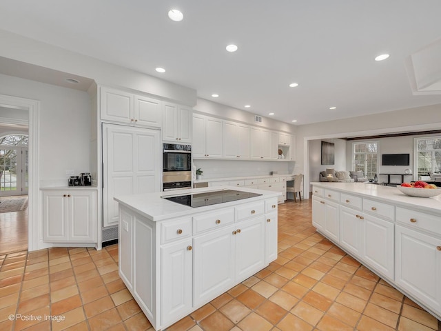 8 Longwood Dr, Burr Ridge, IL 60527 - kitchen with black electric stovetop, recessed lighting, a center island, light countertops, and double oven