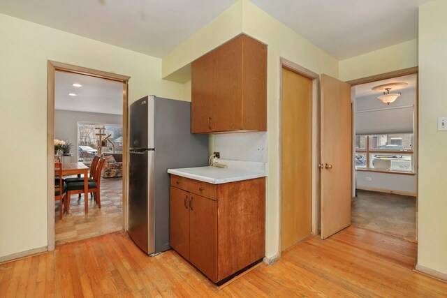 5770 N Forest Glen Ave, Chicago, IL 60646 - kitchen with light wood-style flooring, a healthy amount of sunlight, freestanding refrigerator, and light countertops