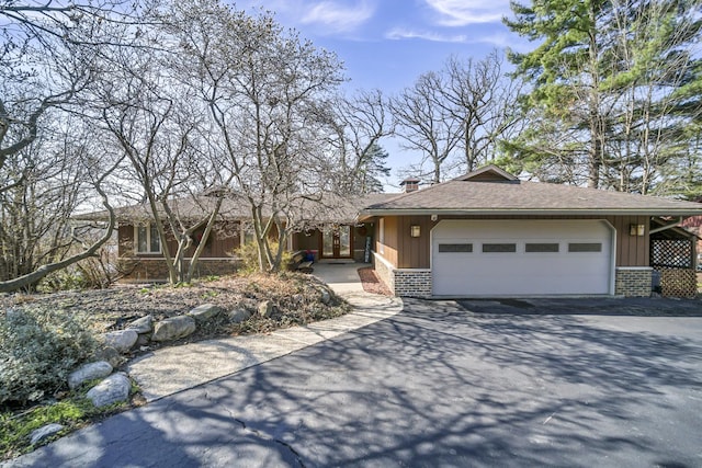 245 Banbury Rd, Mundelein, IL 60060 - ranch-style home featuring driveway, brick siding, board and batten siding, an attached garage, and a chimney