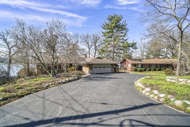 245 Banbury Rd, Mundelein, IL 60060 - view of front of home featuring driveway, an attached garage, and a chimney