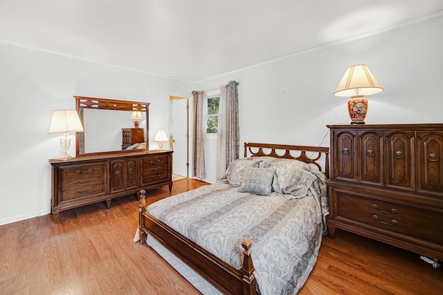 bedroom with light wood-type flooring and ornamental molding