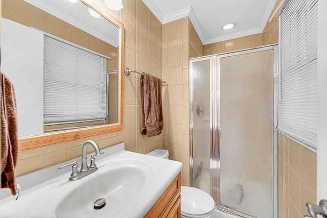 bathroom featuring tile walls, crown molding, toilet, a shower stall, and vanity