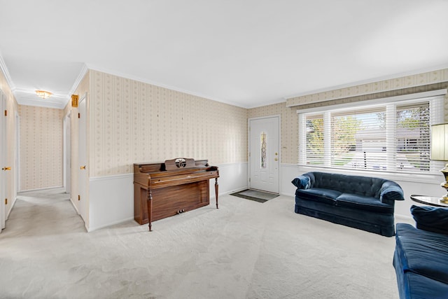 carpeted living area with ornamental molding, wallpapered walls, and wainscoting